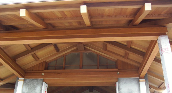 A timber entry in a hybrid timber frame home plan